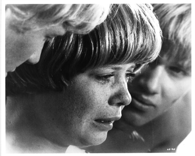 Catherine Burns crying, two boys on either side looking at her.