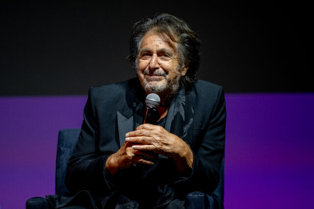 Al Pacino sitting with a microphone on stage