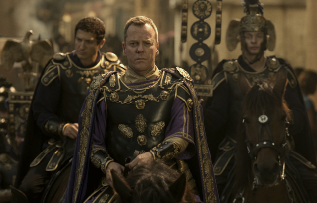 Kiefer Sutherland on a horse in Roman attire, soldiers following behind him.