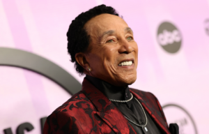 Smokey Robinson in front of a pink backdrop