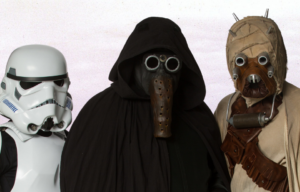 Three cosplayers dressed as a Stormtrooper, Garindan, and a Tusken Raider.