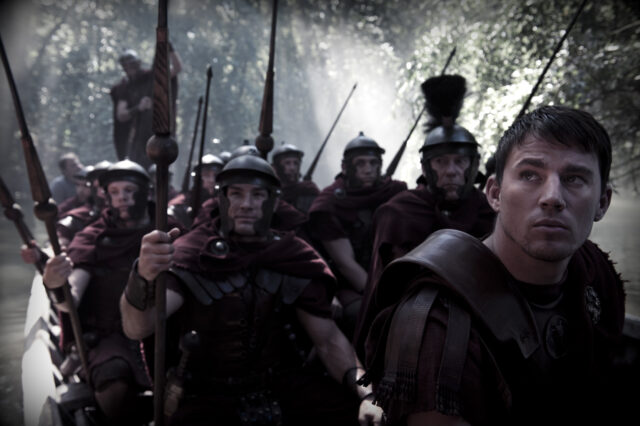 Channing Tatum and other dressed as Roman soldiers in a forest.