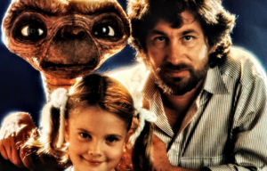 Steven Spielberg, Drew Barrymore, and E.T. posing for a photo together.