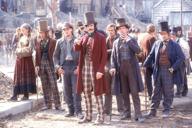 Daniel Day-Lewis and others standing around in a town square.