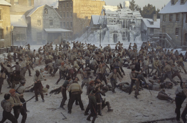 A brawl taking place in a town square with a large group of people.