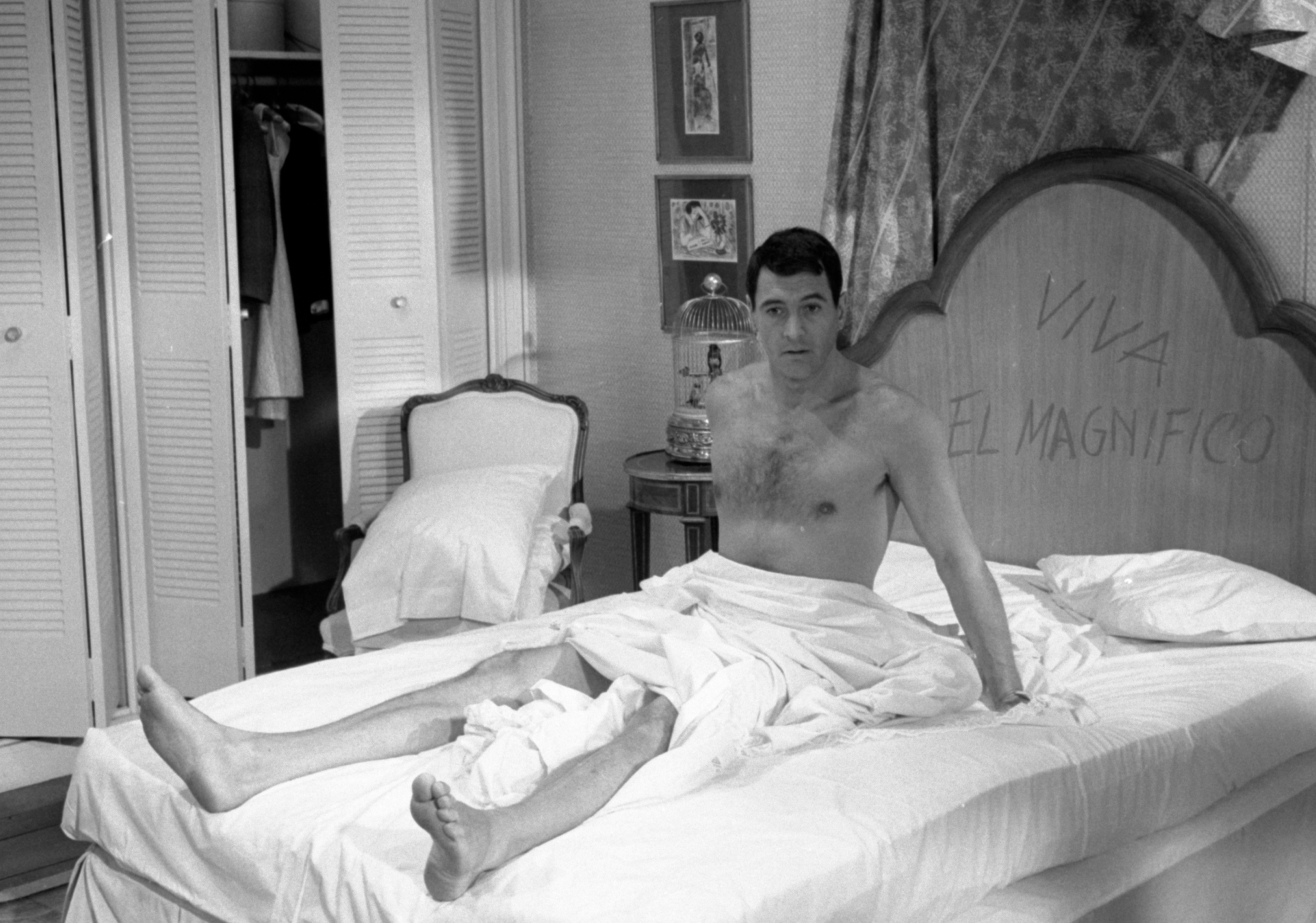 Rock Hudson sitting upright in bed
