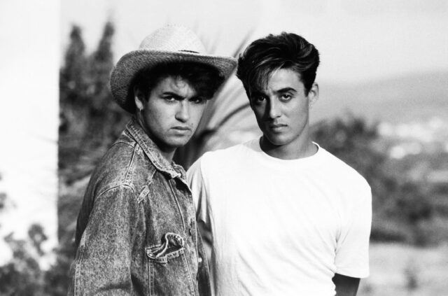 George Michael in a hat standing beside Andrew Ridgeley