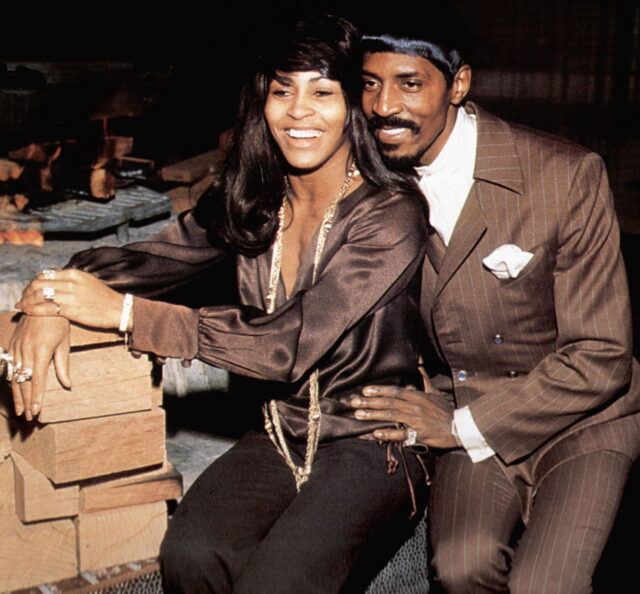 Tina Turner and Ike Turner posing for a photo together sitting down.
