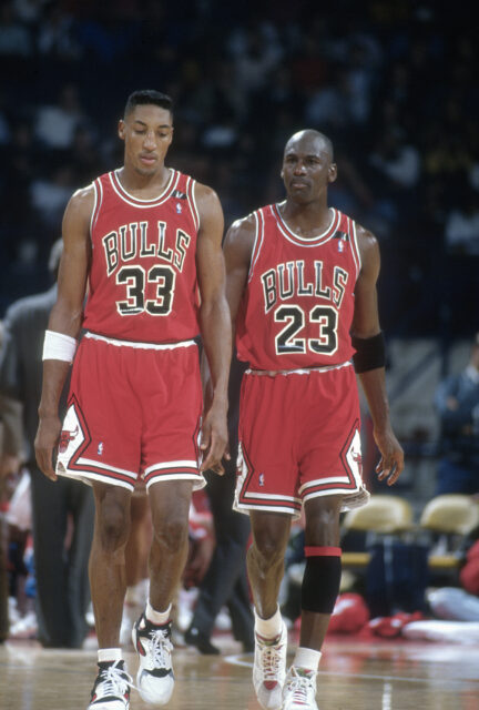 Scottie Pippen and Michael Jordan in Chicago Bulls uniforms on a basketball court.
