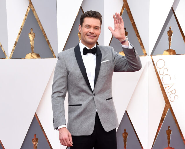 Ryan Seacrest waves while arriving at the Oscars