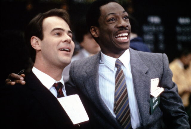 Dan Aykroyd and Eddie Murphy smiling in suits.