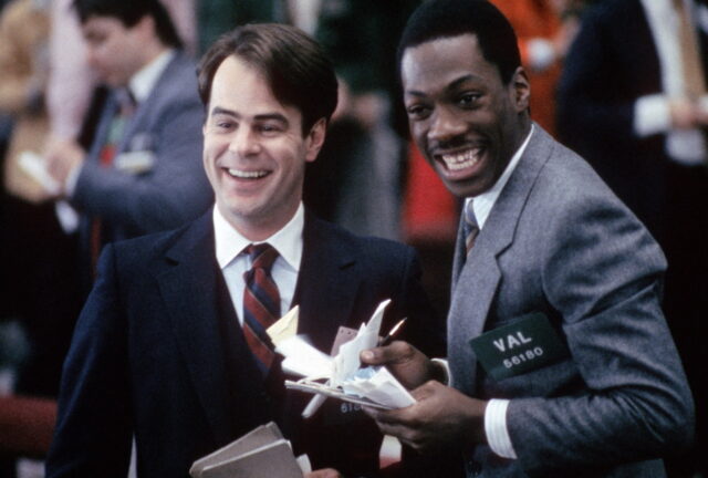 Dan Aykroyd and Eddie Murphy smiling in suits.