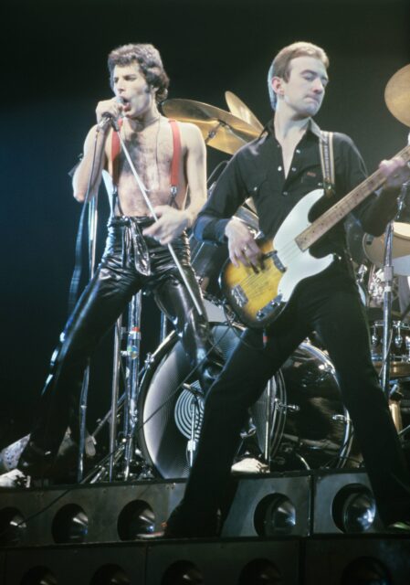 John Deacon and Freddie Mercury of Queen perform on stage.