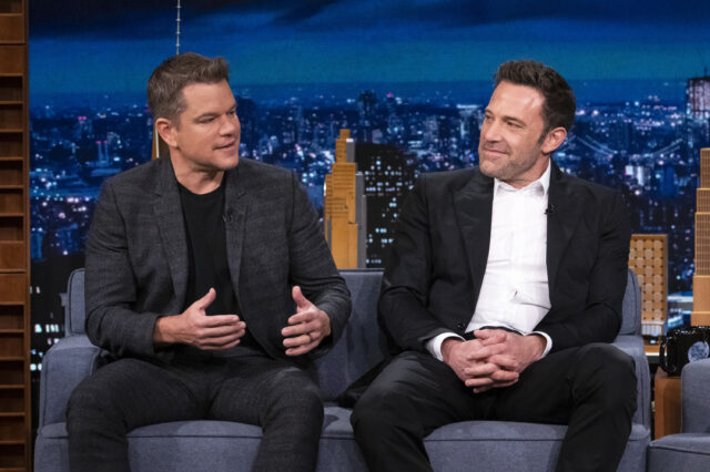 Matt Damon and Ben Affleck sitting beside on another in chairs.