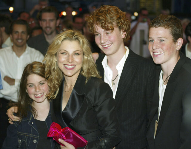 Tatum O'Neal standing with her children, Emily, Kevin and Sean McEnroe, on a red carpet
