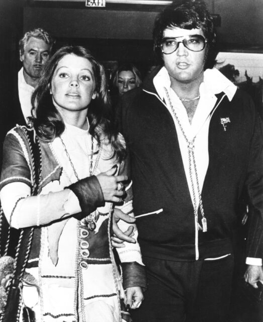 Elvis and Priscilla Presley walking together.
