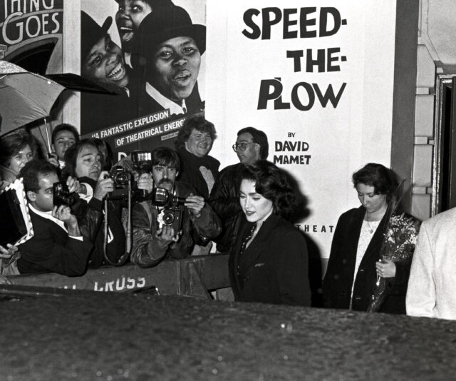 Photographers standing behind a barrier as Madonna walks by