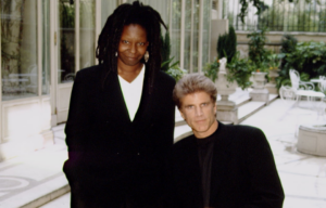 Whoopi Goldberg standing beside a seated Ted Danson.