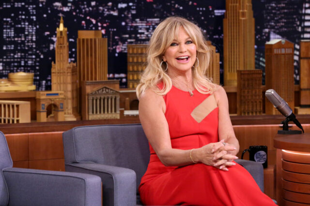 Goldie Hawn, wearing a long red gown, is interviewed by Jimmy Fallon in 2017