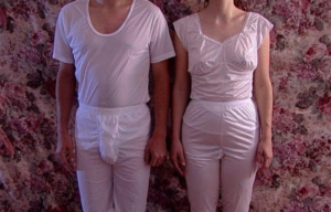 Man and woman standing in matching white Mormon temple garments.