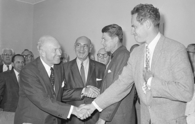 Academy Award winner Charlton Heston (R) shakes hands with Charles S. Boren, vice president of the Association of Motion Picture Producers as the Screen Actors Guild ended its strike against 7 major picture studios. Shown next to Heston is SAG President Ronald Reagan who shakes hands with B.B. Kahne of the AMMP. The strike began on March 7 and halted production on 8 feature films. (Original Caption)