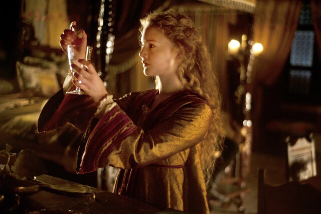 Actor Holliday Grainger as Lucrezia Borgia, putting poison in a glass.