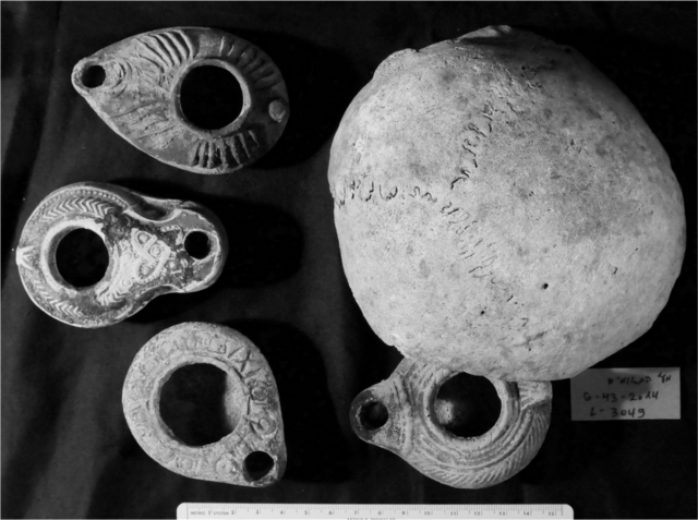 Aerial view of four oil lamps surrounding a human skull.