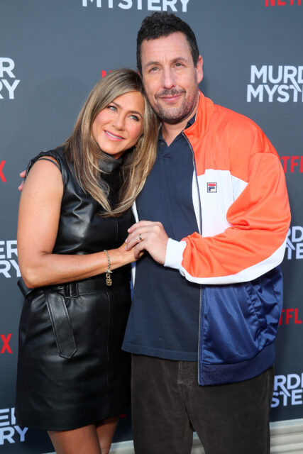 Jennifer Aniston and Adam Sandler standing together on a red carpet