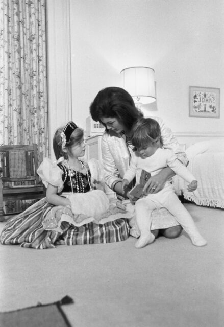 Jackie Kennedy sitting on the floor with her two children. 