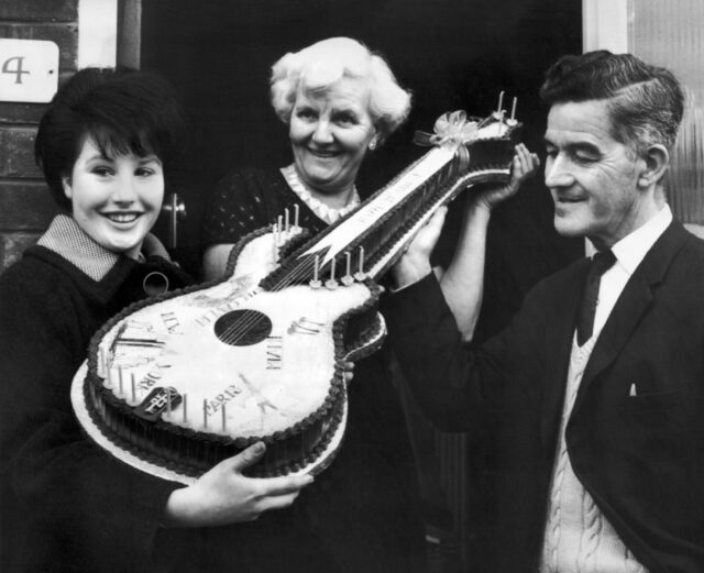 Harold and Louise Harrison, with Beatles fan Jeanette Trust. Louise holding a guitar cake.