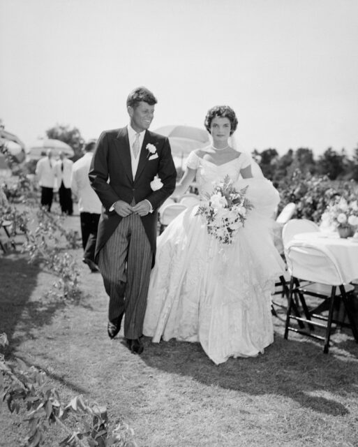 John F. and Jackie Kennedy walking together in their wedding attire
