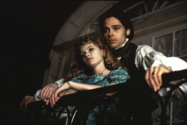 Brad Pitt standing behind Kirsten Dunst on a balcony in 'Interview with the Vampire'