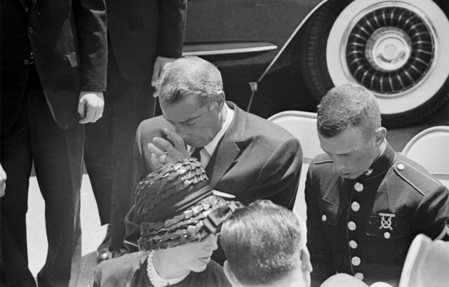 Joe DiMaggio puts his head in his hands and wipes his eyes at Marilyn Monroe's funeral.