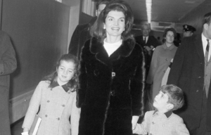 Jackie Kennedy walks with her two children on either side of her.