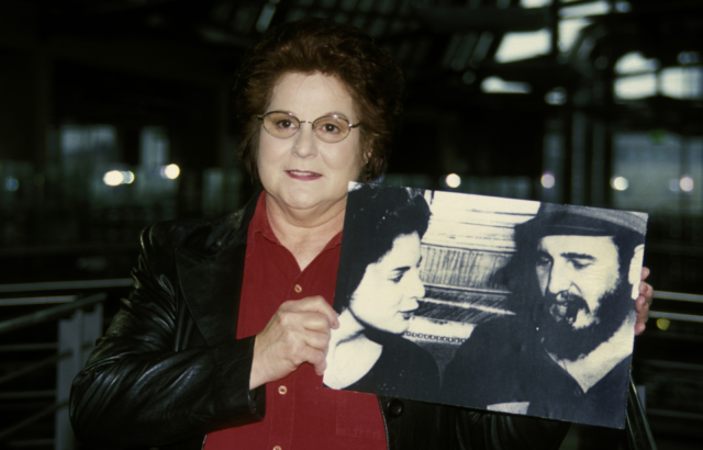Marita Lorenz holding up a photograph of her and Fidel Castro