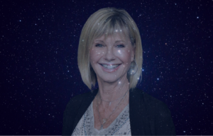 Olivia Newton-John with a starry night sky behind her