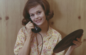 Woman talking on the phone while she holds a vinyl record.