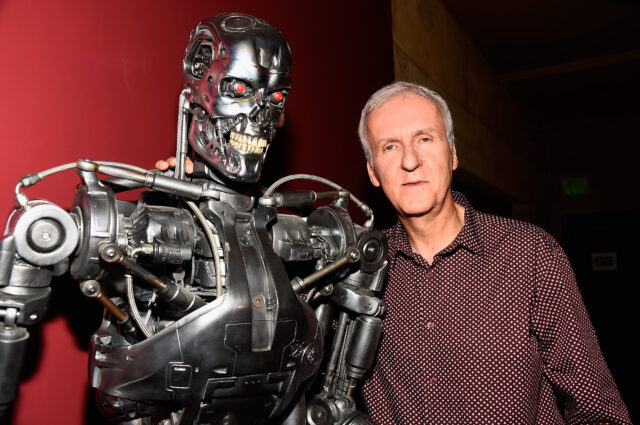 James Cameron standing beside a statue of his Terminator character