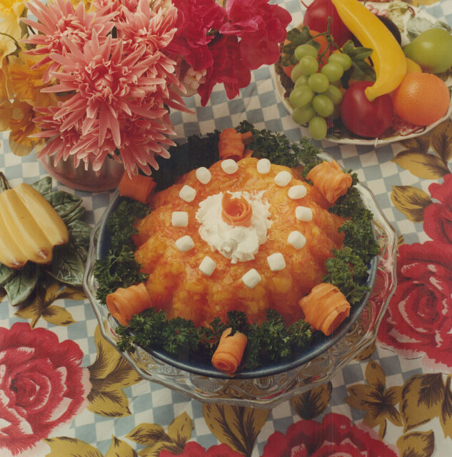 Jell-O salad surrounded by flowers and fake fruit