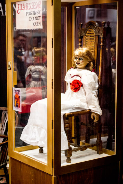 Movie prop Annabelle doll on display in a glass case