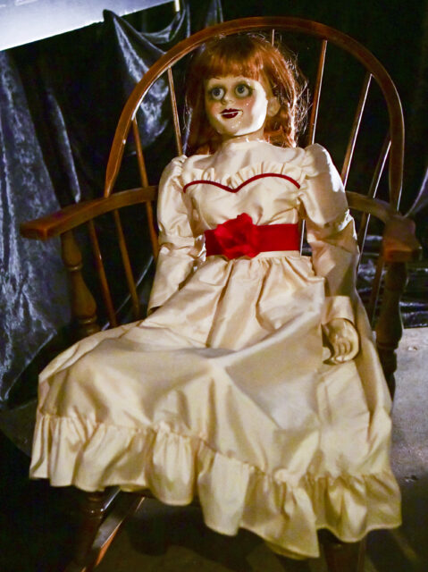 Annabelle doll placed on a wooden chair