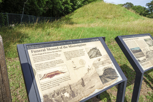 Two stands featuring information about the Funeral Mound of the Mississippians, located just in front of the mound itself.