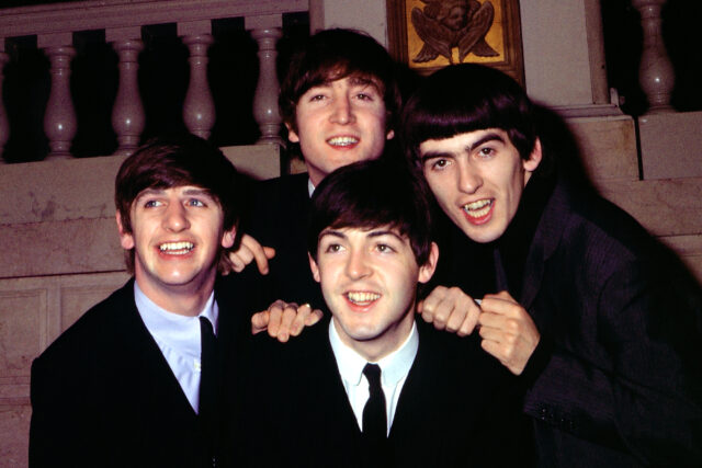 The Beatles sitting and posing around one another.