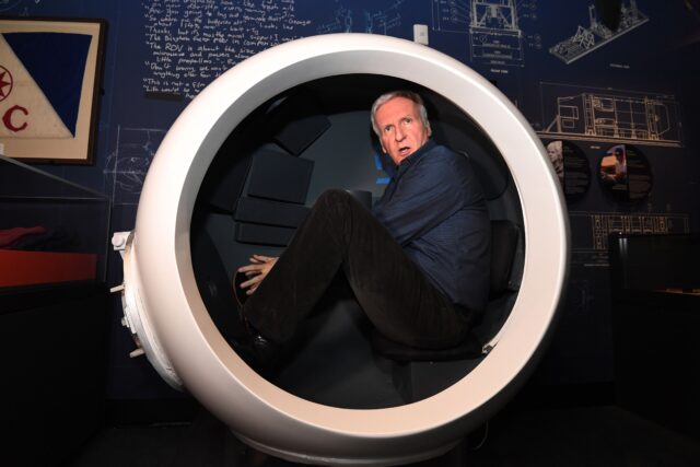 James Cameron sitting in a scale model of the Deepsea Challenger's pilot chamber