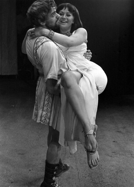 Helen Mirren being held by a fellow actor while at rehearsals