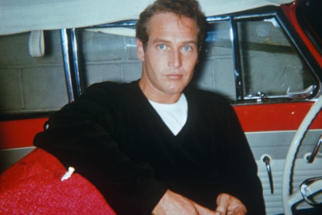 Paul Newman sitting in the driver's seat of a vehicle