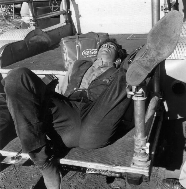 Anthony Perkins laying down with his leg up.