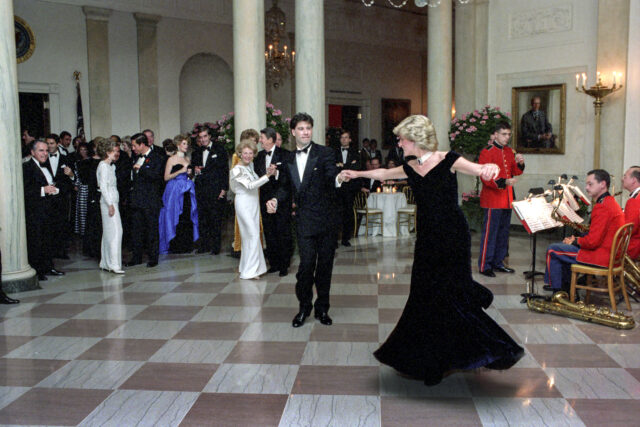 Princess Diana and John Travolta dancing, other people dancing around them.