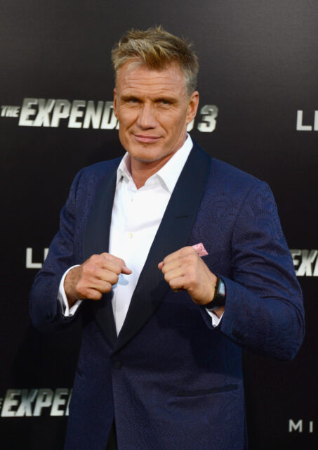Dolph Lundgren holding his hands in fists in front of him.