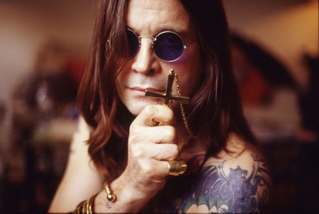 Ozzy Osbourne holding a cross pendant